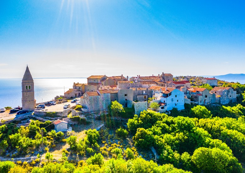 Town of Lubenice with blue sky and sea next to it