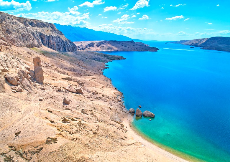 Dry landscape of Metajna next to turquoise water
